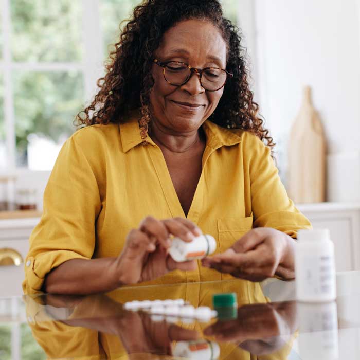 senior woman measuring out prescription pills